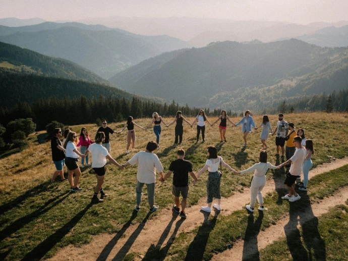 a group of people standing on top of a lush green hillside
